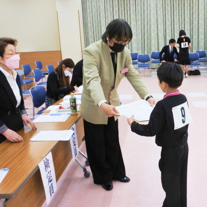 技術検定試験で技術認定状を受け取る生徒